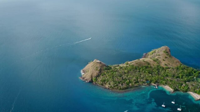 Aerial shot of a maneuvering yacht in the open blue sea and a mountain on the shore (Rodney Bay, Saint Lucia)
