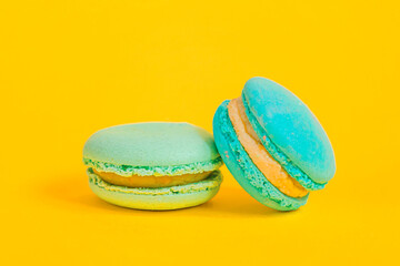 Sweet almond colorful unicorn blue macaron or macaroon dessert cake isolated on trendy yellow modern fashion background. French sweet cookie. Minimal food bakery concept Copy space