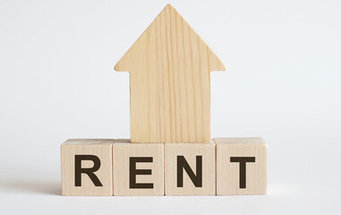 Wooden blocks with the word RENT , house. The concept of the high cost of rent for an apartment or...