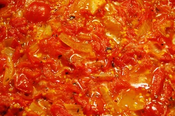 Preparación de salsa de tomate cherry. Salsa recién cocinada en la sartén. Tomate, cebolla y...