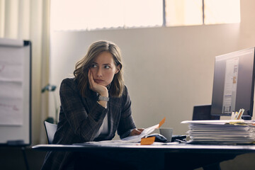Young businesswoman are tired of all the work at her office desk. She is looking away to signal...