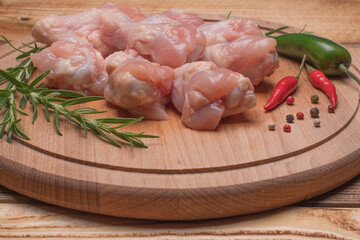 Fresh raw chicken wings on a wooden cutting board.