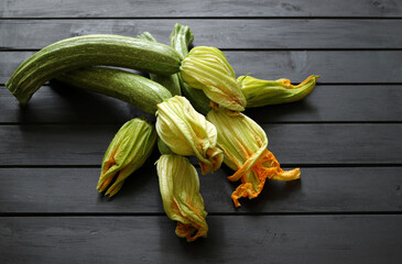 Concetto di verdure. Zucchini freschi con il fiore isolate sulla tavola di legno. Vista dall'alto,...