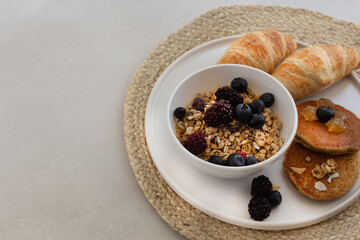 Healthy breakfast concept. Granola with berries, croissants and