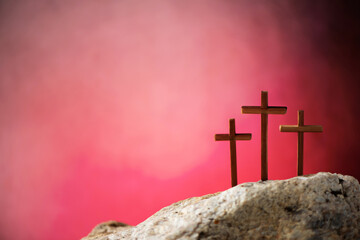 Crucifixion, resurrection of Jesus Christ. Three crosses against red sky on Calvary hill...