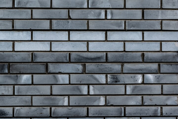 Obraz premium .The wall is made of dark gray textured brick. The texture of the brick wall is gray.