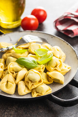 Tortellini pasta. Italian stuffed pasta with basil leaves.