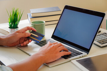 Hands holding credit card and using laptop. Online shopping