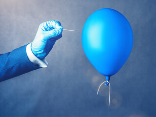 Blue balloon. Man hold needle directed to air balloon. Concept of risk. Copy space.