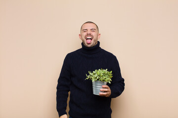 young handsome man with cheerful, carefree, rebellious attitude, joking and sticking tongue out,...