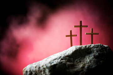 Crucifixion, resurrection of Jesus Christ. Three crosses against red sky on Calvary hill...