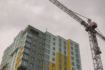 Fototapeta premium construction building process crane high object moody weather urban photography foreshortening from below
