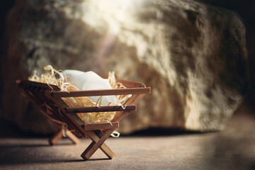Christian Christmas concept. Birth of Jesus Christ. Wooden manger in cave background. Banner, copy...