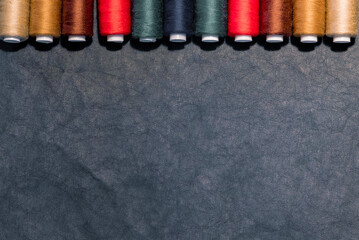 Sewing flat lay with copy space. Top view of sewing supplies, multicolored sewing threads on...