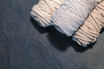 Top view of macrame cotton cords, natural cotton ropes on grey background with copy space for banner design. Handcraft hobby