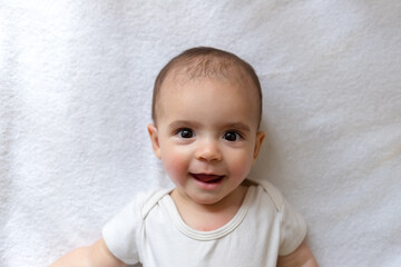 Newborn baby. A little boy in white clothes. Beautiful portrait of a toddler. Big-eyed baby.	