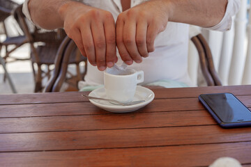 Close-up of the cup uf espresso and the mans hand