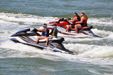 Four teenagers riding jet skis on the Florida Intra-Coastal Waterway near Miami Beach.