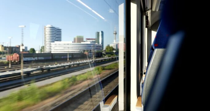 Sunny view of cityscape in D&uuml;sseldorf, Germany through window of moving train. Enjoy outdoor scenery moment during commute and travel by Train.
