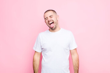 young handsome man with cheerful, carefree, rebellious attitude, joking and sticking tongue out,...