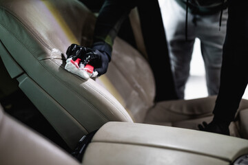 A man cleaning car interior, car detailing (or valeting) concept. Selective focus.