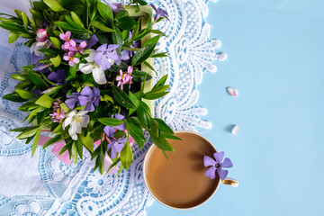 flower arrangement on a blue background with a cup of coffee. Concept healthy breakfast.