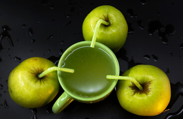Green apples around a mug of Apple juice