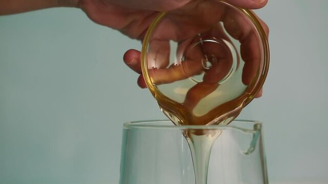Adding honey to a jar, adding lemon juice and stiring lemonade
