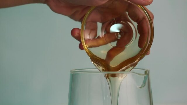 Adding honey to a jar, adding lemon juice and stiring lemonade