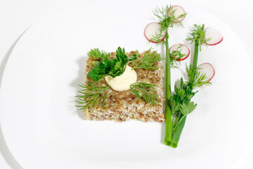 Buckwheat casserole on a white plate decorated with greens