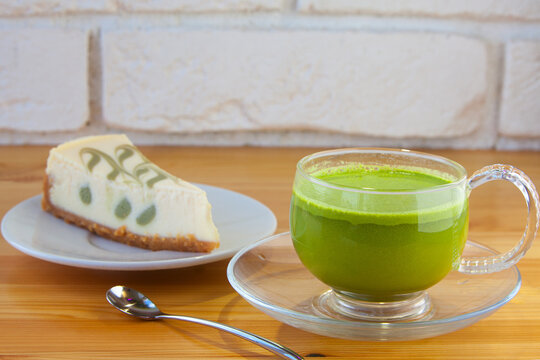 appetizing green cheesecake with matcha tea on wooden background
