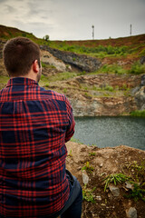 Naklejka premium Man looking at the lake on a cloudy day