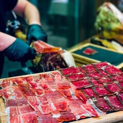 High angle shot of Spanish Jamon slices on a wooden surface