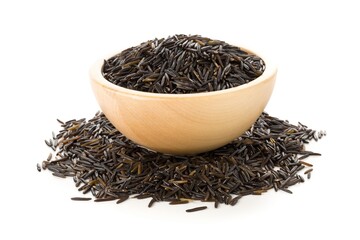 Heap of uncooked, raw, black wild rice grains in wooden bowl over white