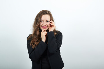 Young Attractive Woman Brunette In In A Black T-Shirt And Sweater On White Background, Cute Female Holding Hands Near Her Face, Gentle Person