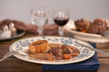 Well-cooked beef shank in wine sauce served in an antique plate