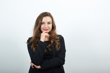 Young Attractive Woman Brunette In In Black T-Shirt And Sweater On White Background, Focused Female Holding Hand To The Chin, A New Idea. Smart People, Intellectuals