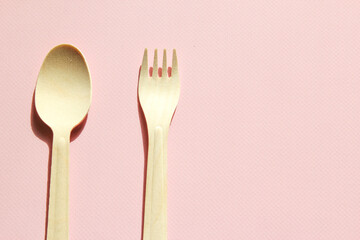 Spoon and fork on the pink background. Eco-friendly tableware.