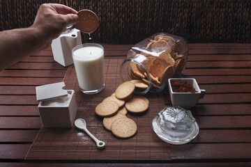 still life of cookies milk azurac cocoa, in rustic brown colors dipping cookies