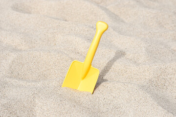 Fototapeta na wymiar Yellow shovel toy on the beach