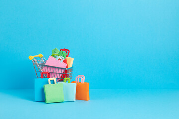 Shopping trolley full of paper bags. Sesonal sale, online deals, discounts, promotion, shopping addiction idea