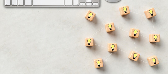 cubes with lightbulb symbols and a keyboard on concrete background