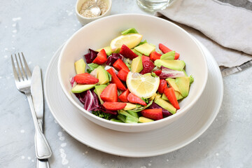 keto salad with avocado and strawberries on a white plate. kegogenic food recipe. healthy lunch or lunch