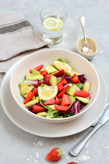 keto salad with avocado and strawberries on a white plate. kegogenic food recipe. healthy lunch or lunch