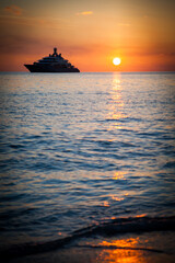 Fototapeta na wymiar Silhouette of a yacht at sunset in the ocean