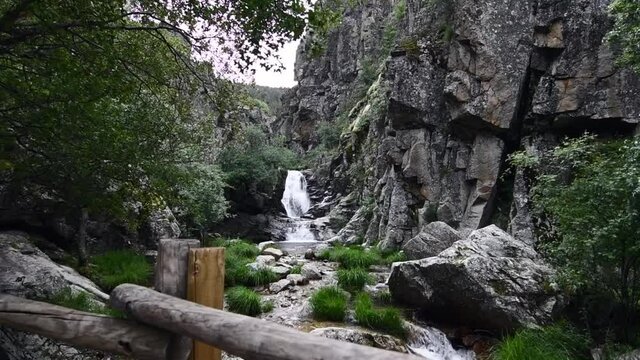 Small and beautiful waterfall in the middle of a very rocky area with lots of nature around in a natural park 