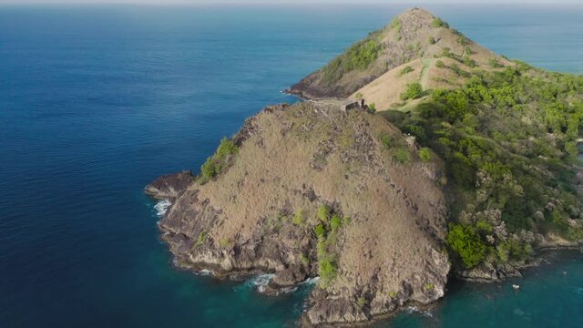 Aerial shot of a Fort Rodney on a mountain with trees in the sea from all sides at Rodney Bay, Saint Lucia