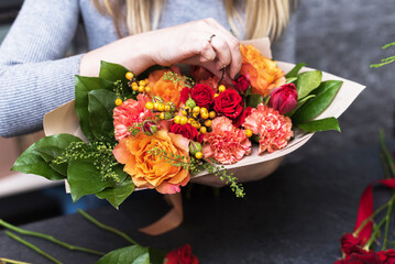 Girl collects a bouquet of various flowers. Small business