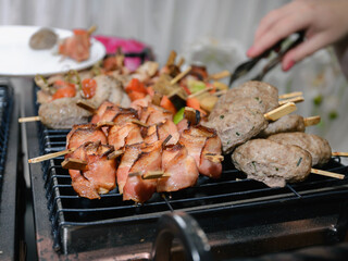 Pork cooked on the grill. Juicy flavorful slices of bacon and kebab on skewer fried on the barbecue.