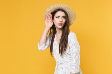 Curious young brunette woman girl in white dress hat posing isolated on yellow background studio...